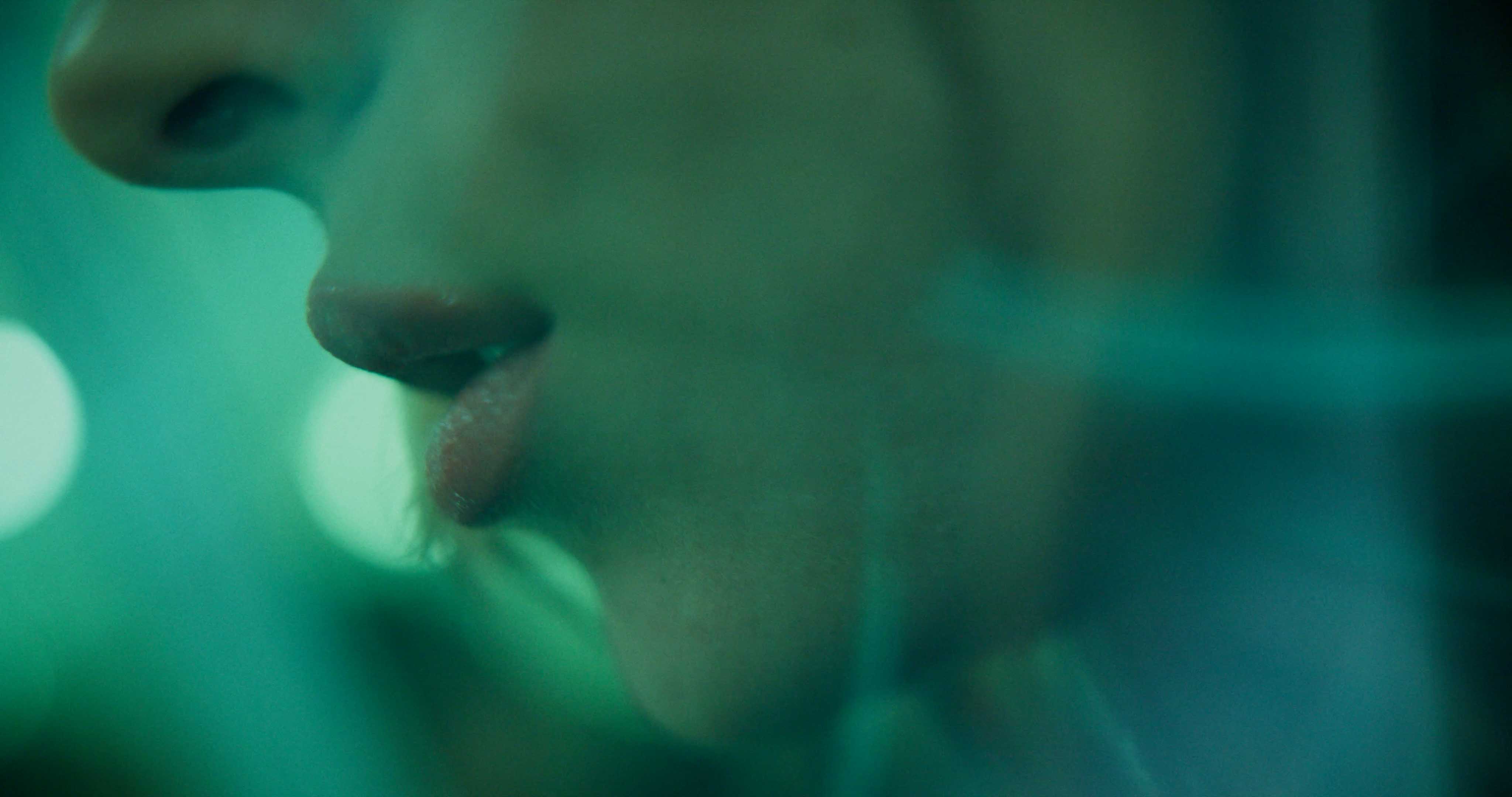 Rear view of a Porsche GT3 entering a foggy racetrack curve at dawn, headlights piercing the mist.